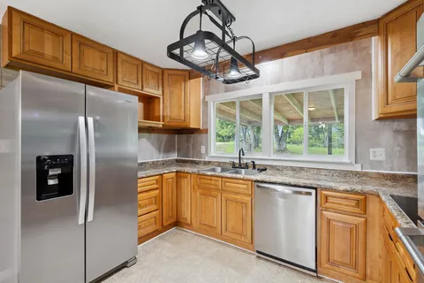 a kitchen with stainless steel appliances granite countertop a refrigerator and a sink