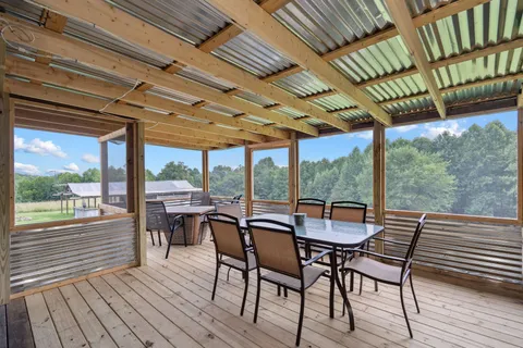 a view of a patio with table and chairs and wooden floor