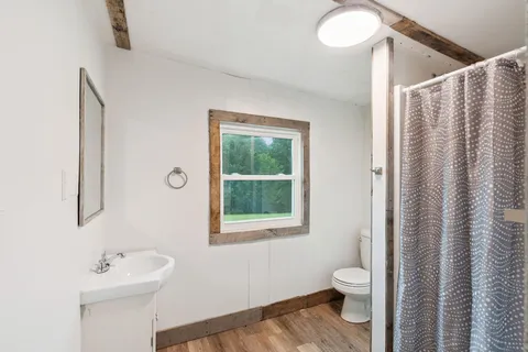 a front view of a house with a garden and trees