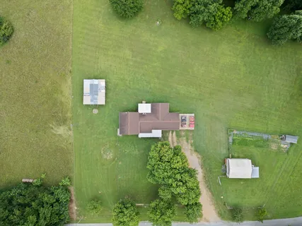 an aerial view of residential houses with outdoor space and trees