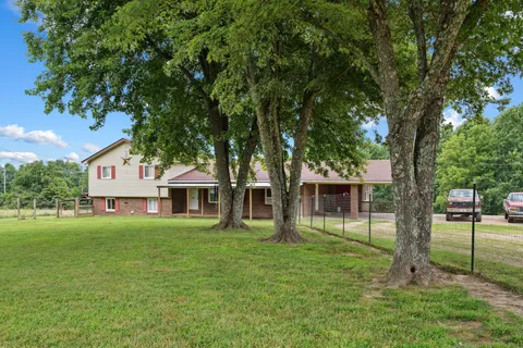 a front view of a house with a garden and trees