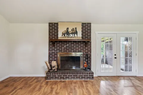 a view of a livingroom with wooden floor and a fireplace