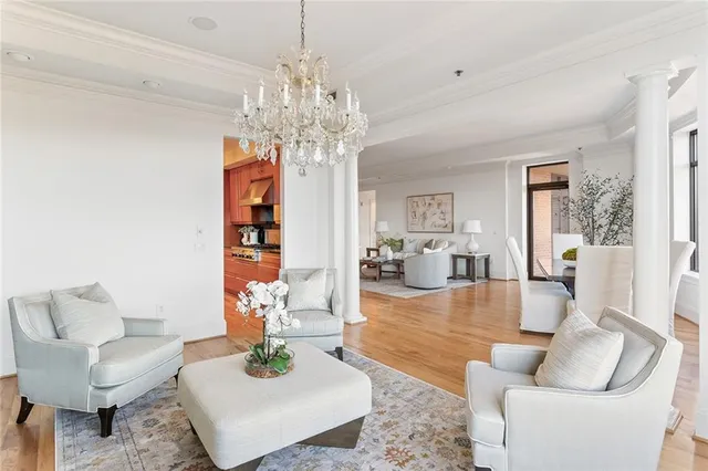 a living room with furniture a chandelier and a dining table