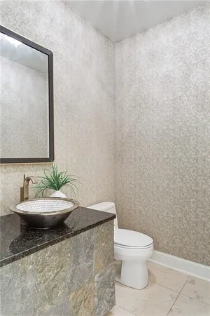 a bathroom with a toilet a sink and mirror