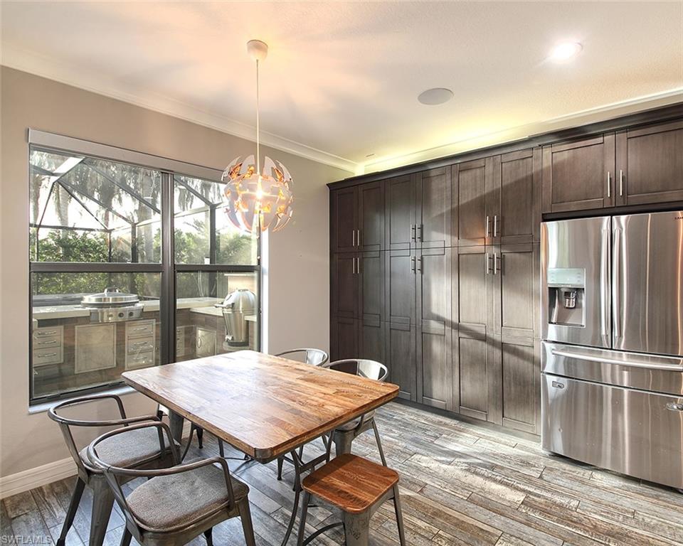 13693 Mandarin Circle Naples, FL 34109 - Photo 11 of 29 a kitchen with a table and refrigerator