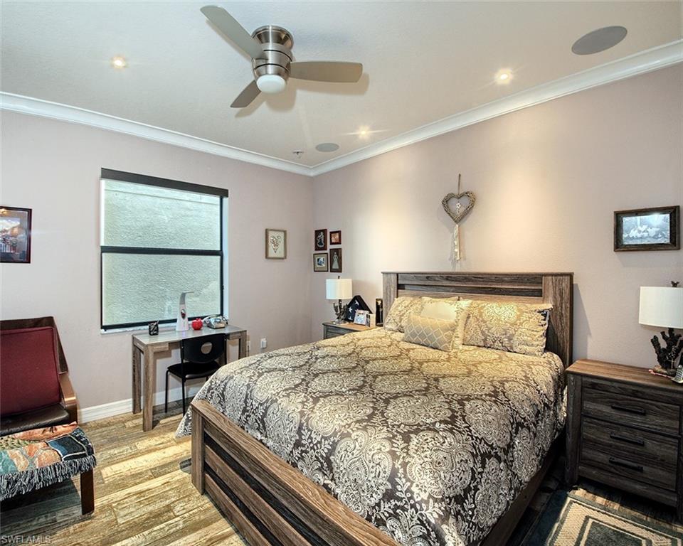 13693 Mandarin Circle Naples, FL 34109 - Photo 13 of 29 a bedroom with a bed and wooden floor