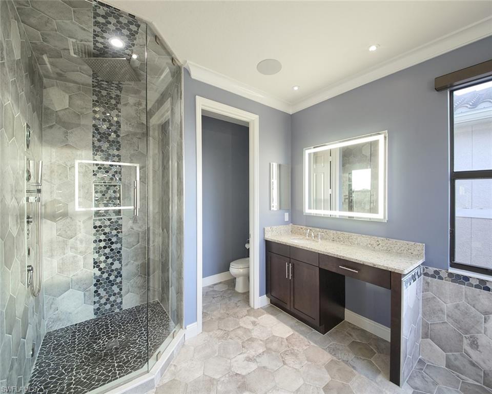 13693 Mandarin Circle Naples, FL 34109 - Photo 16 of 29 a spacious bathroom with a glass door shower and a sink