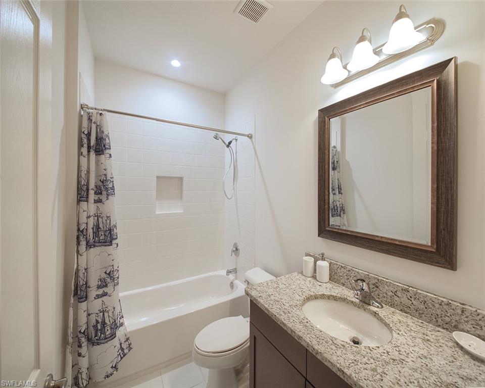 13693 Mandarin Circle Naples, FL 34109 - Photo 19 of 29 a bathroom with a granite countertop sink toilet and shower