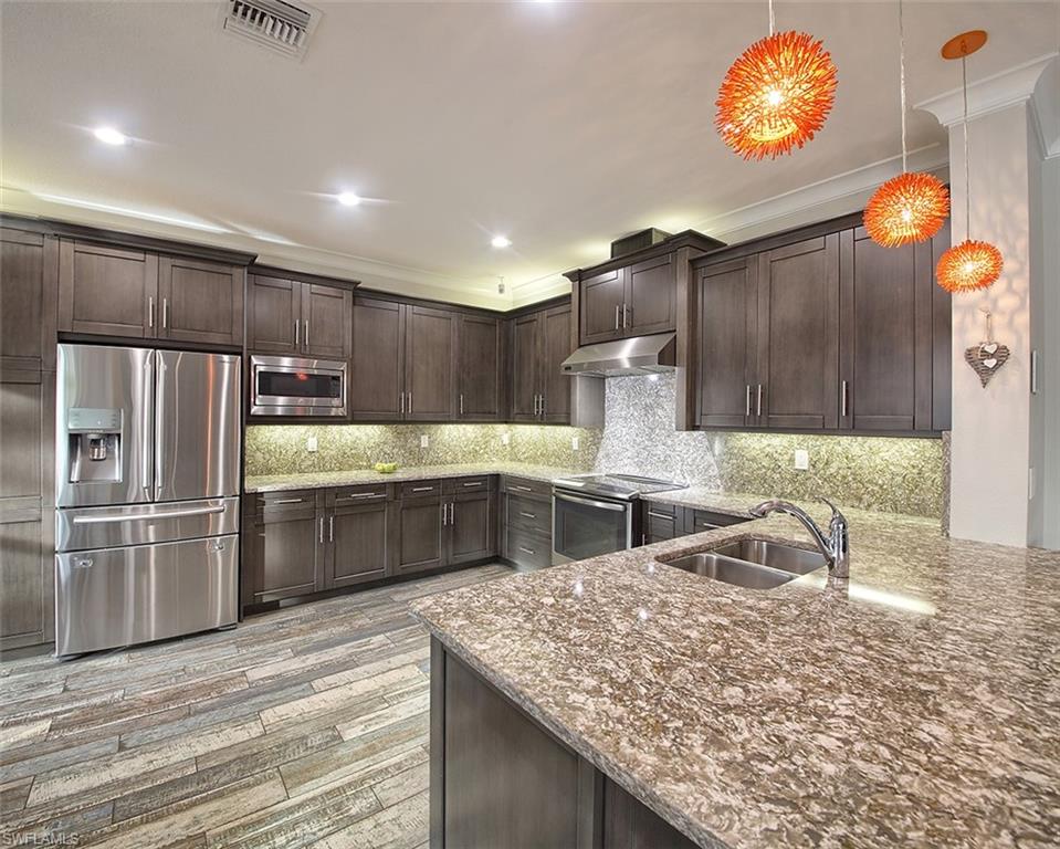 13693 Mandarin Circle Naples, FL 34109 - Photo 10 of 29 a kitchen with stainless steel appliances granite countertop a sink refrigerator and microwave