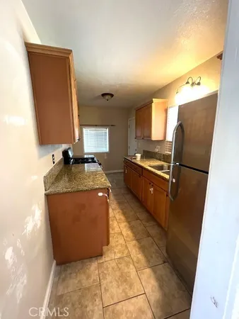 a kitchen with granite countertop a refrigerator and a stove