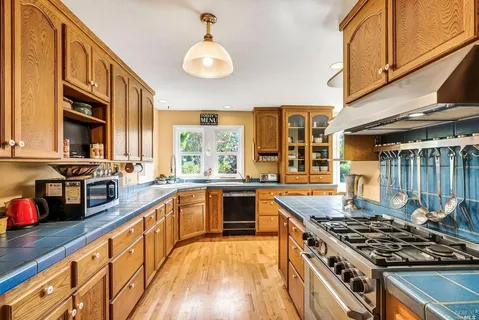 a large kitchen with stainless steel appliances granite countertop a stove and a sink