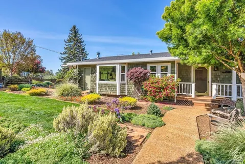 a view of a house with backyard sitting area and garden