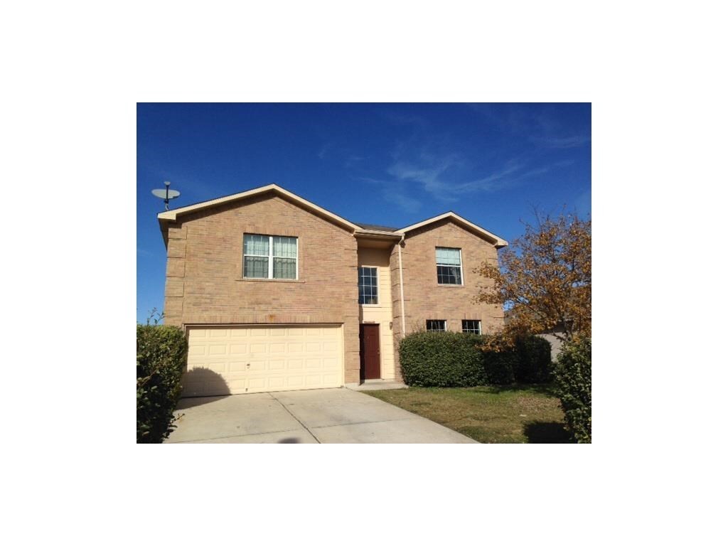 View of front of home with driveway, an attached garage, and brick siding