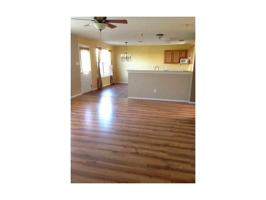 120 Rinehardt Street Hutto, TX 78634 - Photo 3 of 7 Unfurnished living room featuring dark wood-style flooring, a chandelier, and a ceiling fan