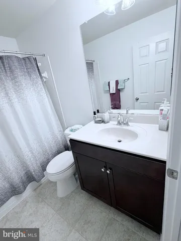 a bathroom with a sink vanity mirror and toilet