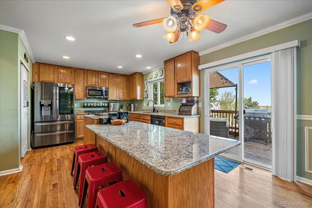 a kitchen with stainless steel appliances granite countertop a sink refrigerator and cabinets