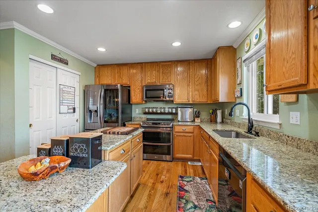 a large kitchen with stainless steel appliances granite countertop a sink and cabinets