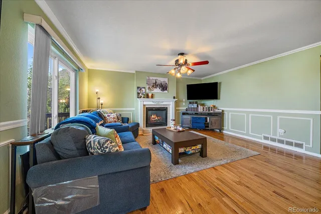 a living room with furniture a flat screen tv and a fireplace