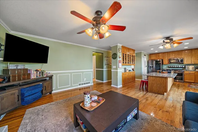 a living room with furniture kitchen view and a flat screen tv