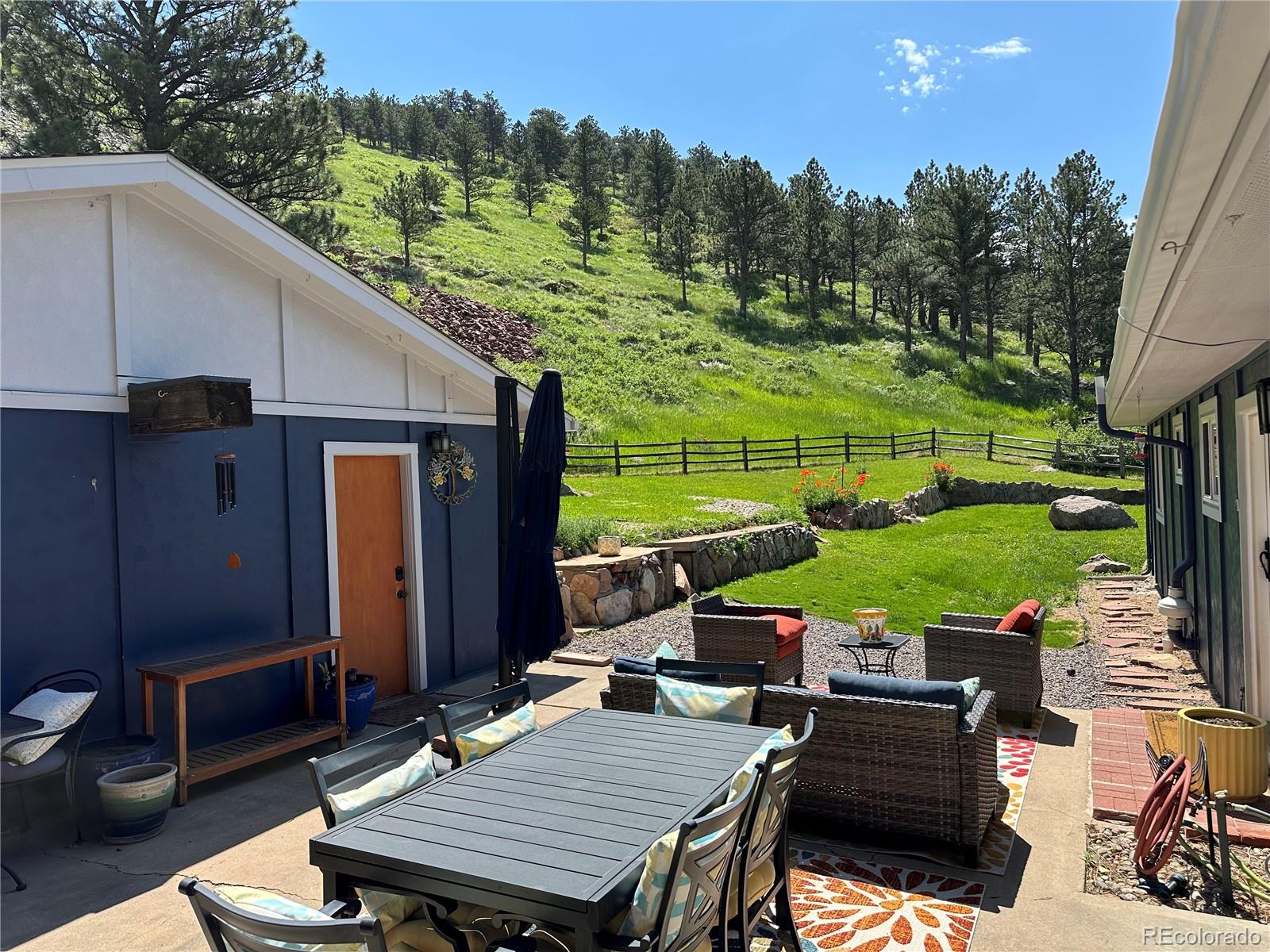 5384 Olde Stage Road Boulder, CO 80302 - Photo 9 of 49 a view of a patio with table and chairs a barbeque grill with wooden fence