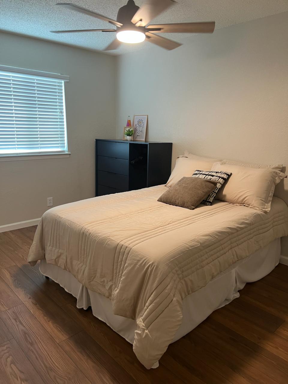 2401 Manor St Road, Unit 118 Austin, TX 78722 - Photo 14 of 17 a bedroom with a bed and wooden floor