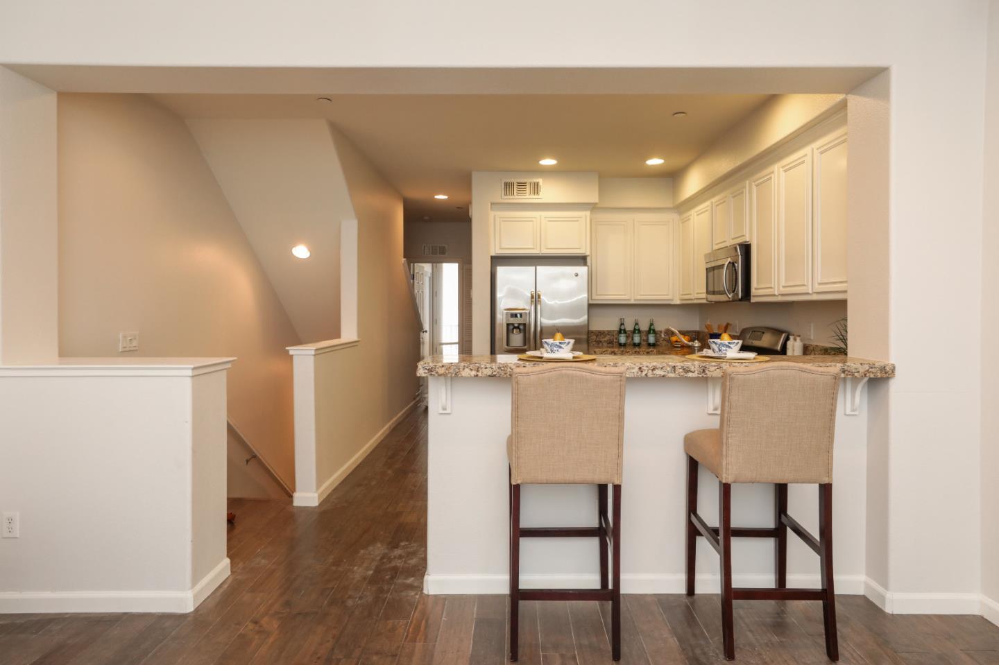 1756 Snell Place Milpitas, CA 95035 - Photo 4 of 22 a kitchen with kitchen island white cabinets and refrigerator