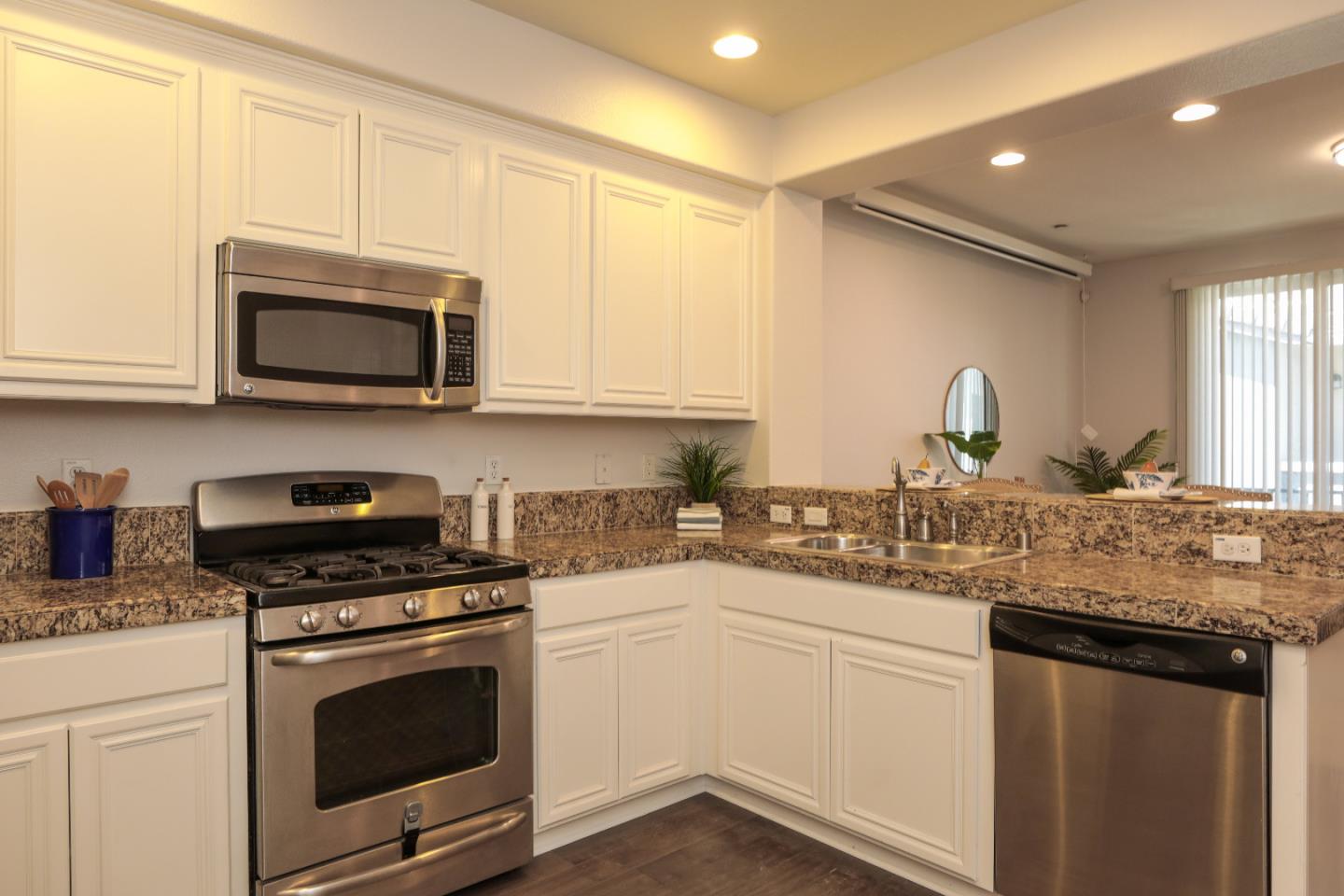 1756 Snell Place Milpitas, CA 95035 - Photo 6 of 22 a kitchen with granite countertop a sink cabinets and stainless steel appliances