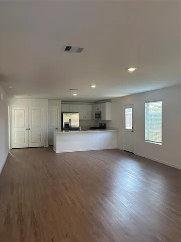 a view of empty room with wooden floor and window