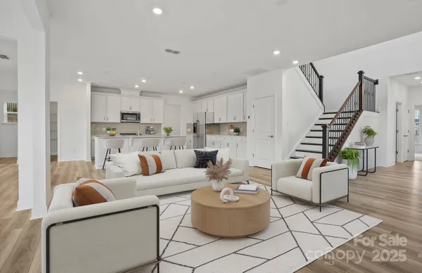 a living room with furniture and a wooden floor