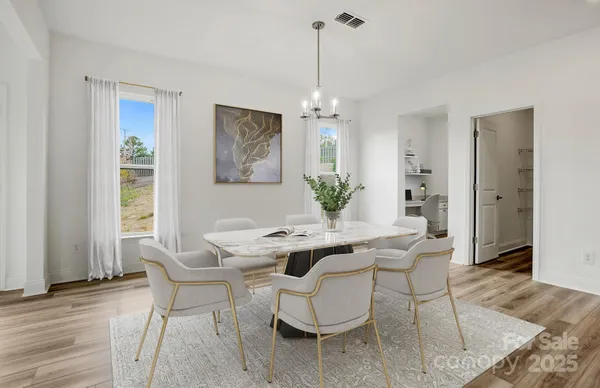 a dining room with furniture a chandelier and wooden floor
