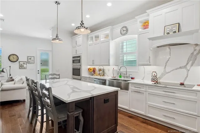 a kitchen with a dining table chairs and white cabinets