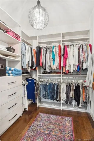 a view of walk in closet with clothes and shoes