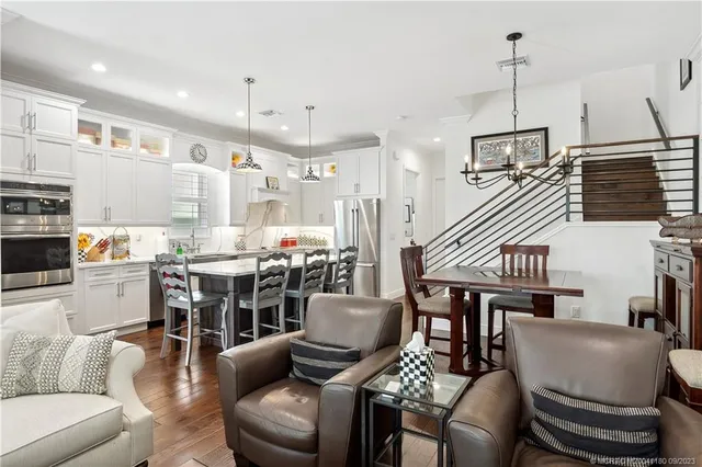a living room with furniture kitchen view and a chandelier