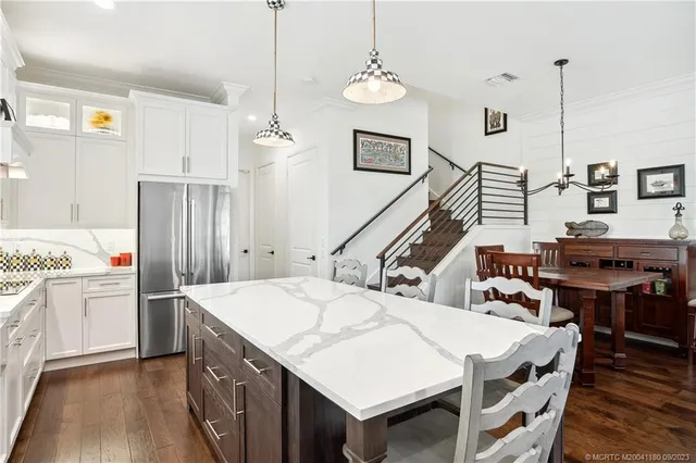 a living room with stainless steel appliances kitchen island granite countertop furniture and wooden floor