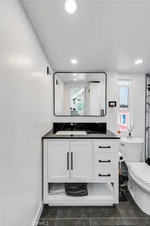 a bathroom with a sink a toilet and a mirror