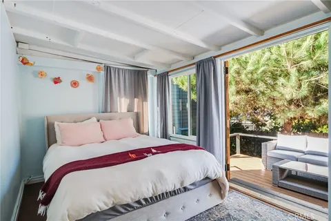 a bedroom with a bed and a large window with outer view