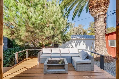 a roof deck with couches and potted plants