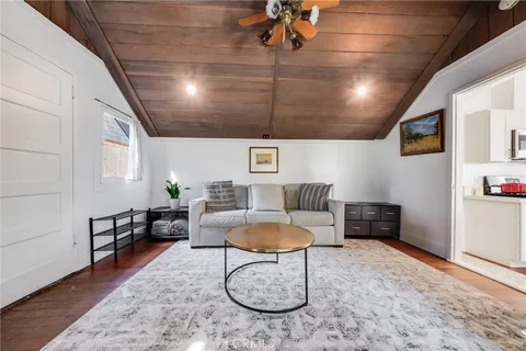 a living room with furniture a rug and white walls