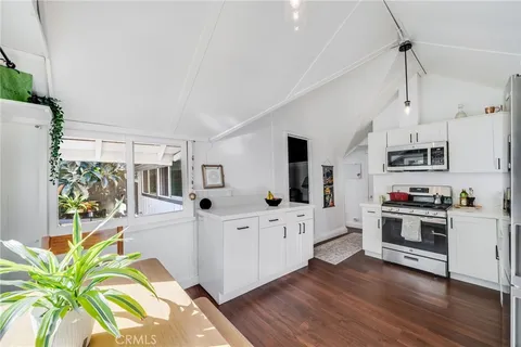 a kitchen with white cabinets and appliances
