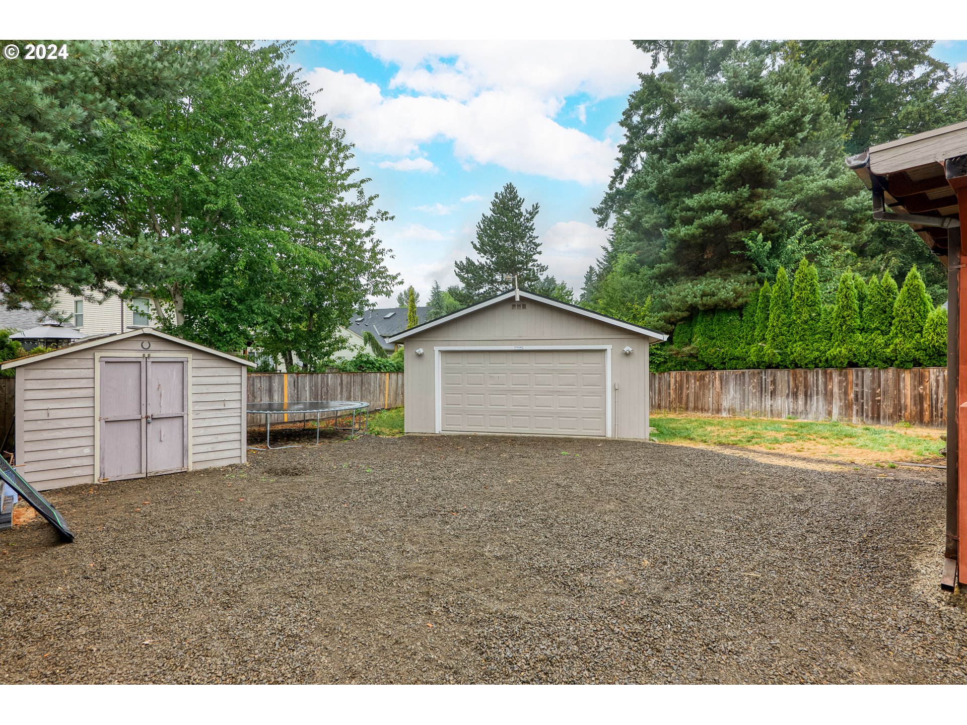 216 Southwest Sutherland Way Beaverton, OR 97006 - Photo 2 of 19 a view of backyard of house with large trees and wooden fence