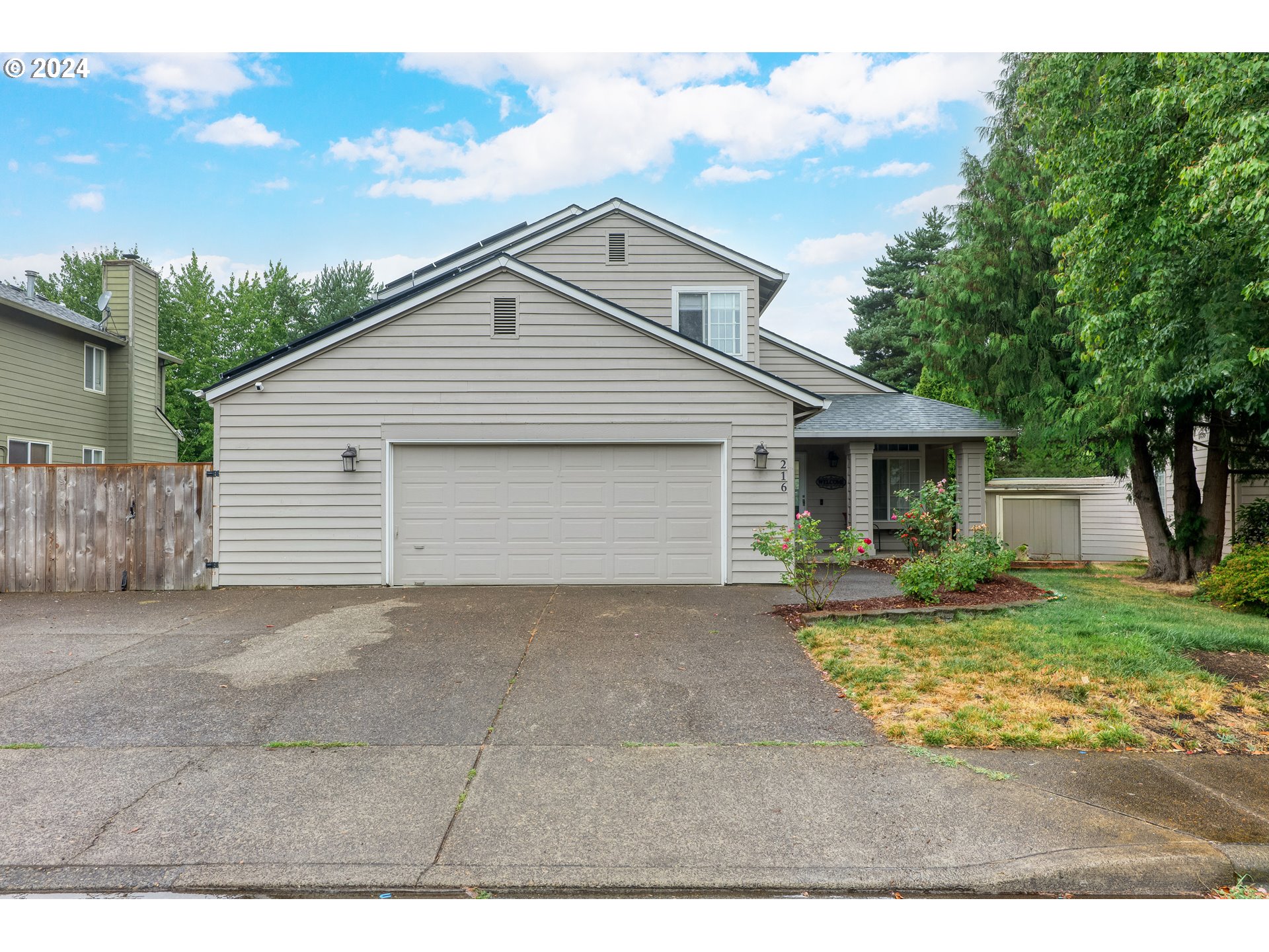 216 Southwest Sutherland Way Beaverton, OR 97006 - Photo 3 of 19 a front view of a house with a yard and garage