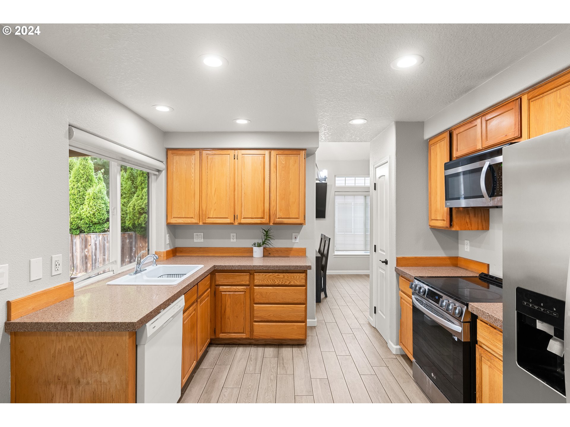 216 Southwest Sutherland Way Beaverton, OR 97006 - Photo 8 of 19 a kitchen with stainless steel appliances granite countertop a sink a stove and a refrigerator