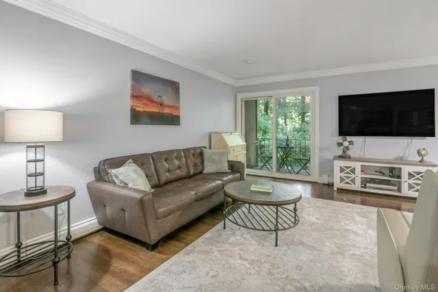 a living room with furniture a flat screen tv and a large window