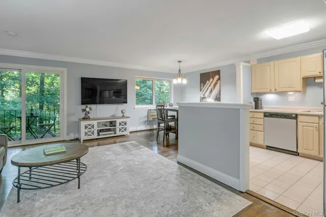 a living room with furniture a flat screen tv and large windows