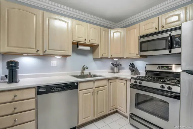 a kitchen with white cabinets and appliances