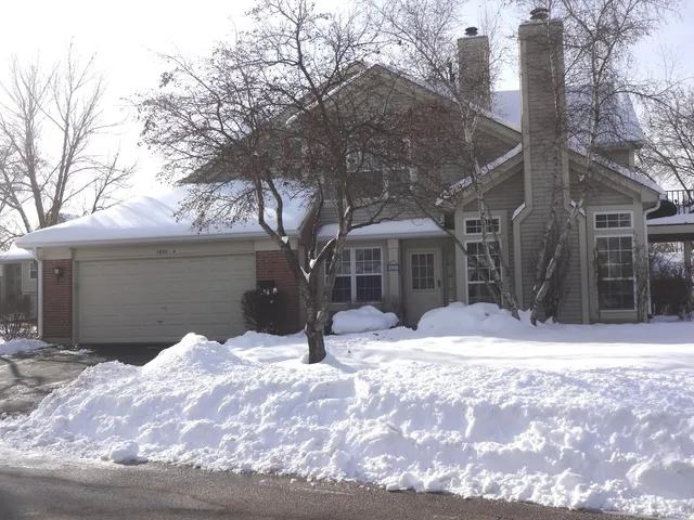 a view of a house with a yard covered in snow