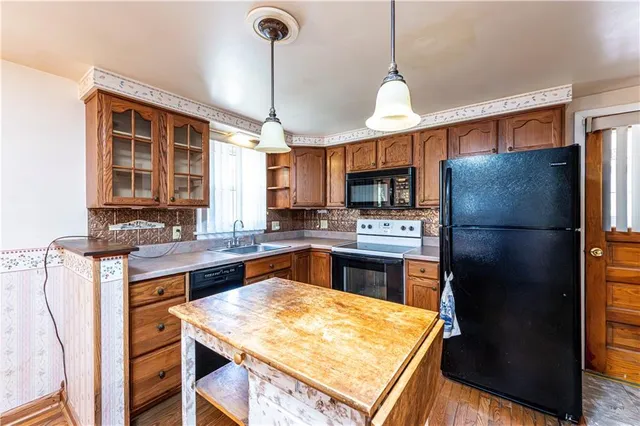 a kitchen with a refrigerator a sink and cabinets