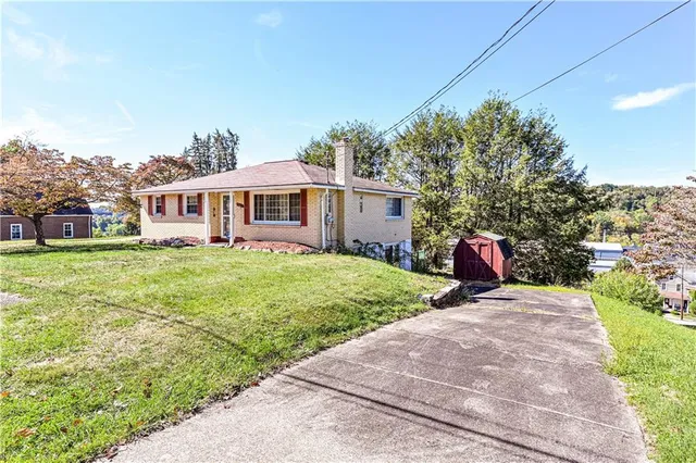 a front view of a house with a garden and yard