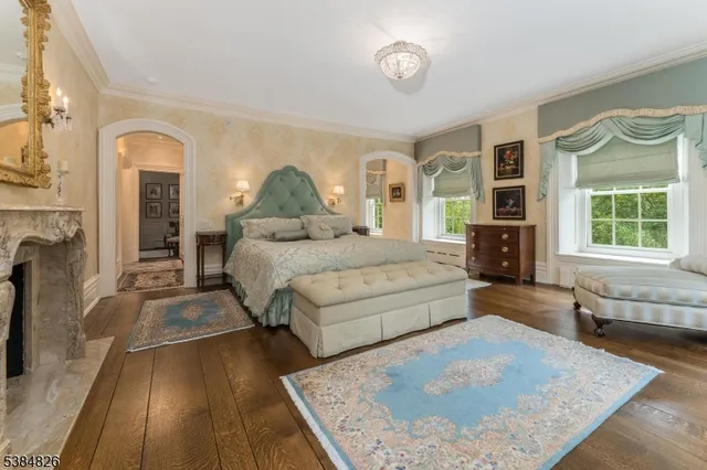 a bed sitting in a spacious bedroom next to a window