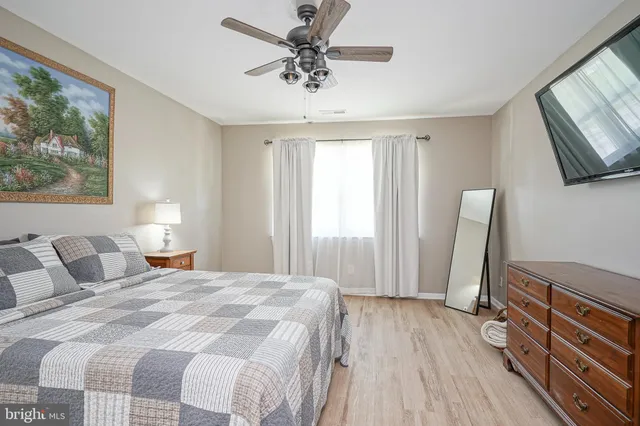 a bedroom with a bed a window and dresser